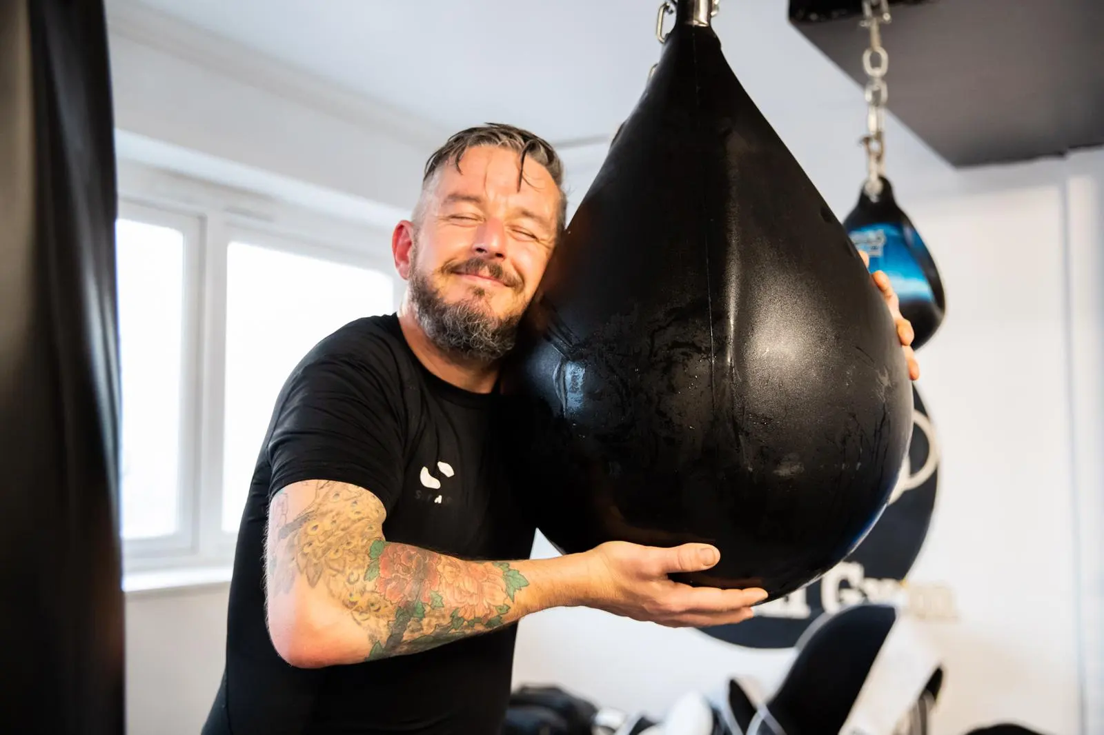 Member hugging the heavy bag after training